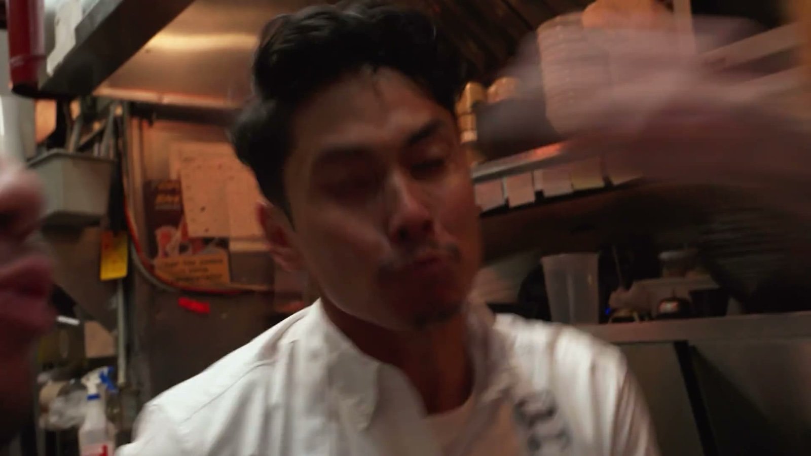 Young chef in a restaurant kitchen, moody lighting