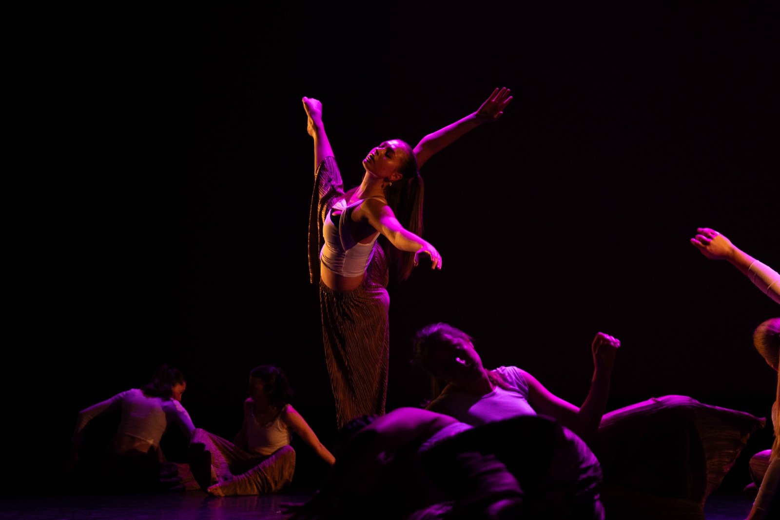 Contemporary dancers performing on a dark stage