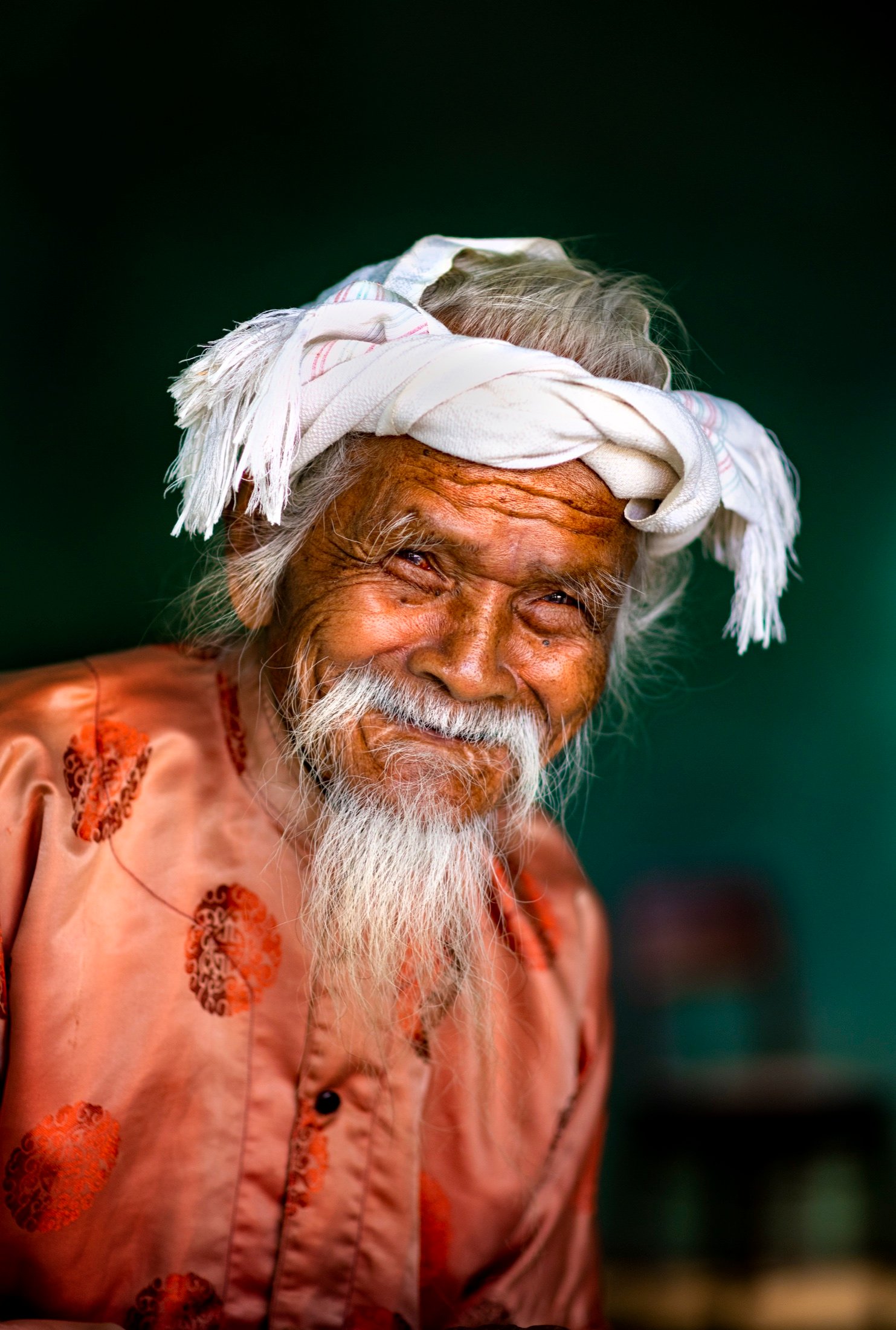 Close-up smiling portrait of an elderly man in a white headwrap